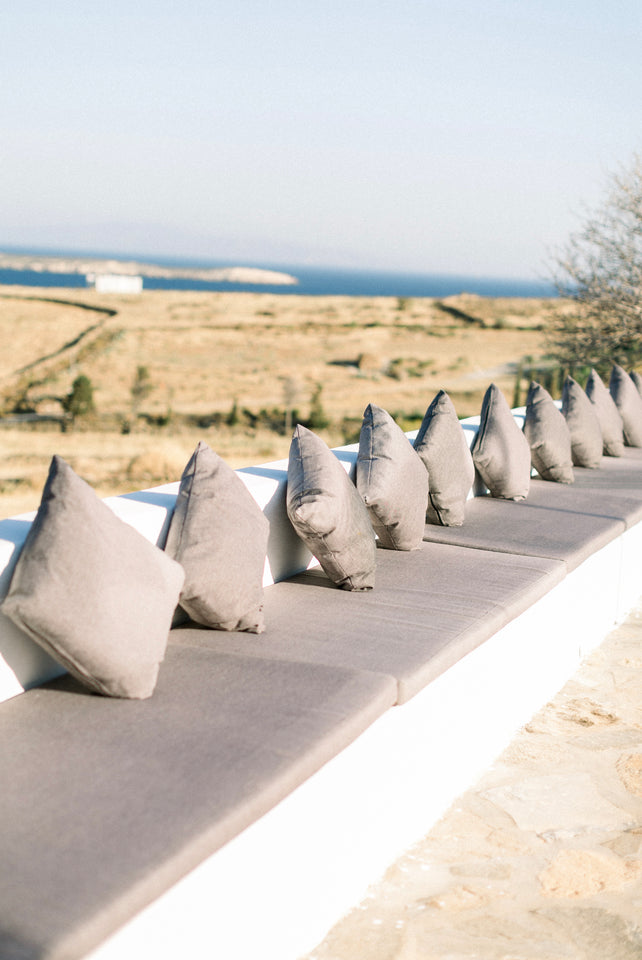 Grey cushions and comfortable sofas, with the view on the aegean sea from the reception area of The Secret View during a wedding reception in Paros, Greece