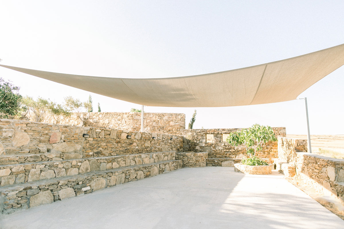 Outdoor salon, with beige canopy for an intimate wedding ceremony or a standing cocktail, at The Secret View, a wedding venue in Paros, Greece