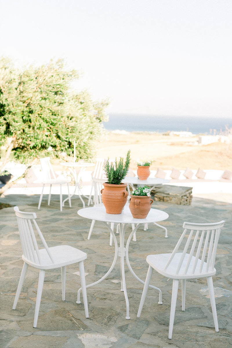 White table and chairs during a wedding cocktail hour at The Secret View, a wedding venue in Paros, Greece